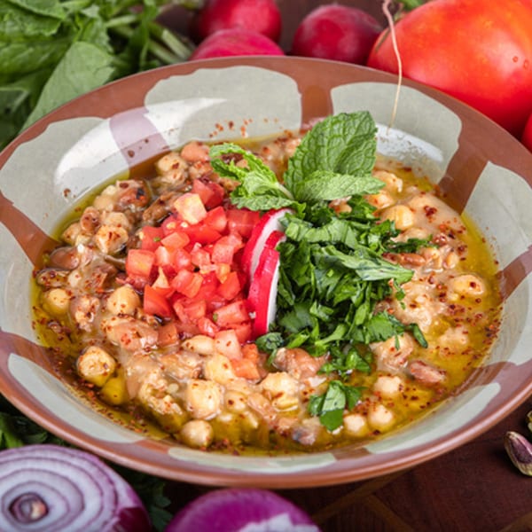 Omaya's Lebanese Cuisine foul mudammas, topped with diced tomatoes, fresh mint, and parsley.